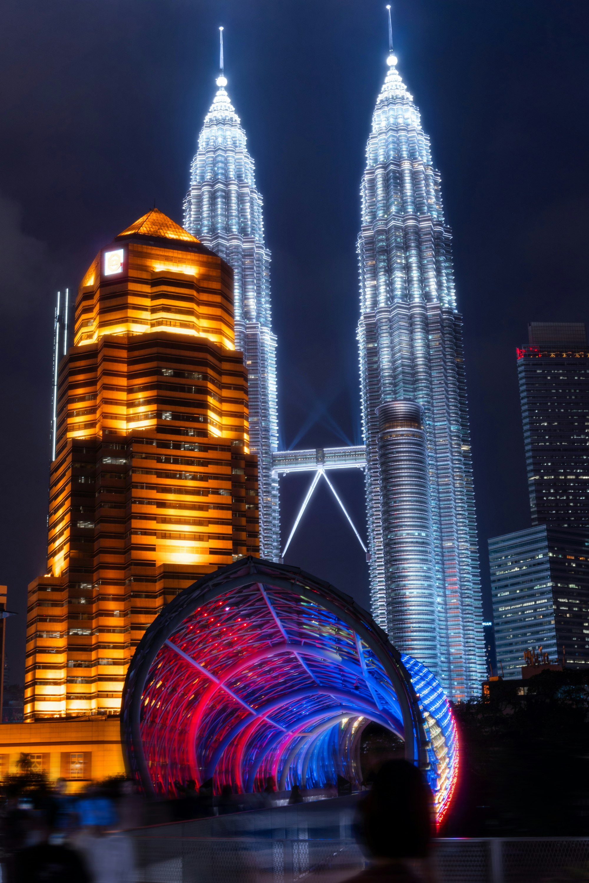 Evening view of illuminated Petronas Twin Towers from observation deck height showing city transition to night